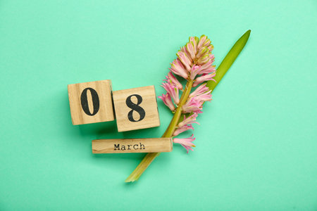 Wooden cube calendar with date MARCH 8 and hyacinth flower on color backgroundの写真素材