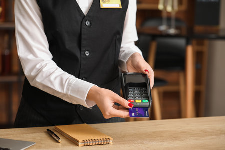 Waiter with payment terminal in cafe