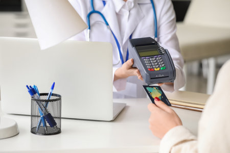 Patient paying for consultation in clinic via terminalの写真素材