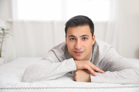 Morning of young man lying on bed with soft mattressの写真素材