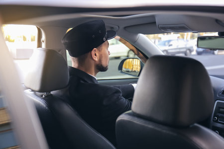 Handsome chauffeur driving luxury carの写真素材