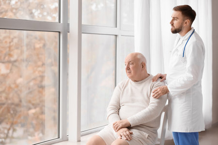 Doctor and senior man undergoing course of chemotherapy in clinic. Prostate cancer awareness concept