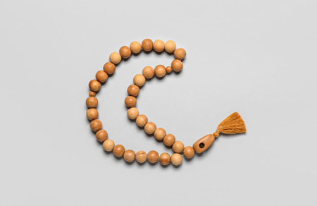 Prayer beads in shape of crescent for Ramadan on gray background