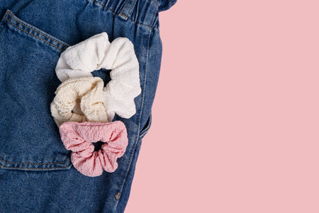 Stylish scrunchy and jeans on pink background, closeupの写真素材