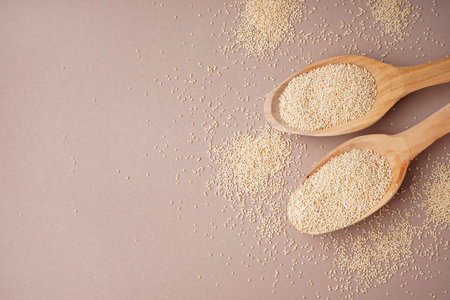 Wooden spoons of amaranth seeds on color backgroundの写真素材