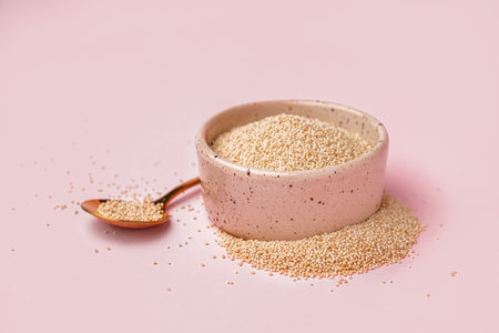 Bowl and spoon with amaranth seeds on pink backgroundの写真素材