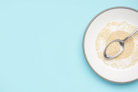 Plate and spoon with amaranth seeds on color backgroundの写真素材