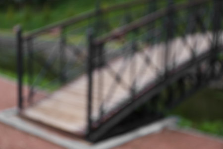 Blurred view of beautiful bridge across lake in parkの写真素材