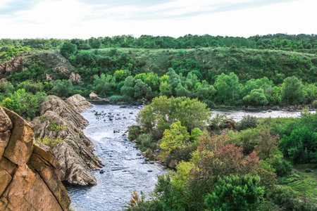 View of beautiful river with green trees and rocksの写真素材