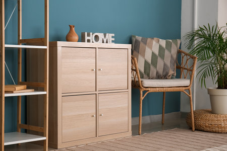 Interior of stylish living room with wooden drawers and armchair