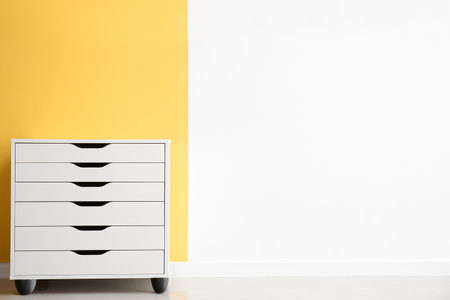 White chest of drawers near color wallの写真素材