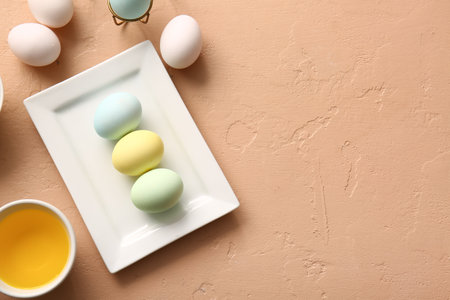 Plate with painted Easter eggs and bowl of natural dye on color backgroundの写真素材