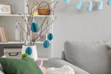 Vase with tree branches and Easter eggs on table in living roomの写真素材