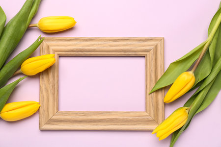 Composition with empty picture frame and yellow tulip flowers on pink background. hello springの写真素材