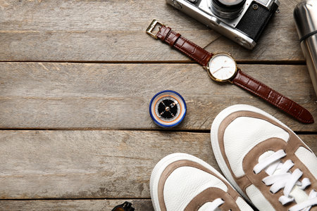 Compass with sneakers, wristwatch and photo camera on wooden backgroundの写真素材