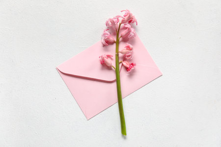 Envelope and beautiful hyacinth flower on light backgroundの写真素材
