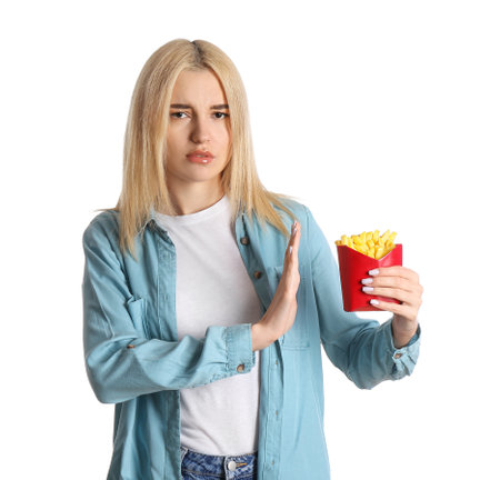 Beautiful young woman refusing to eat french fries on white background