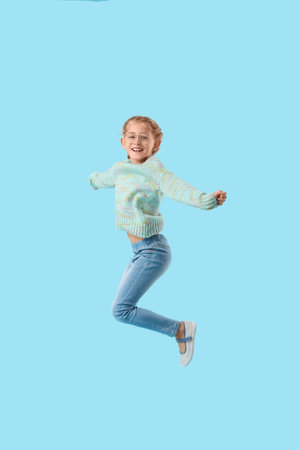 Jumping little girl on color background