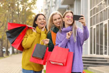 Beautiful young women taking selfie outdoors after shopping