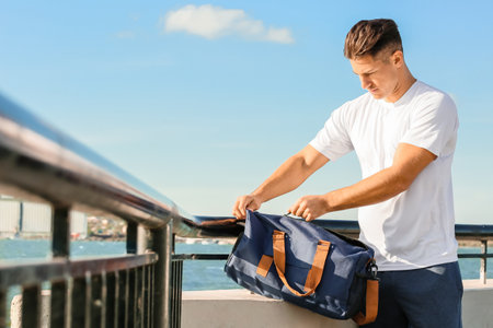 Sporty young man with bag outdoorsの写真素材