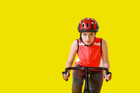 Female cyclist riding bicycle on color background
