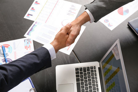 Businessmen shaking hands in officeの写真素材