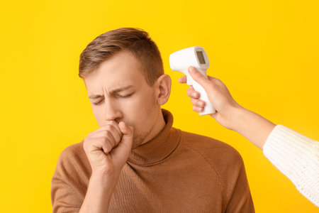 Measuring of ill man's temperature on color background