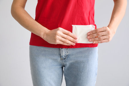 Young woman with menstrual pad on gray background, closeupの写真素材