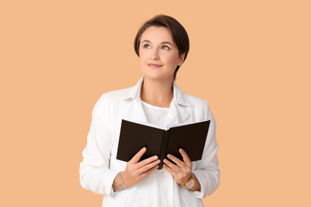 Beautiful young woman with book on color background