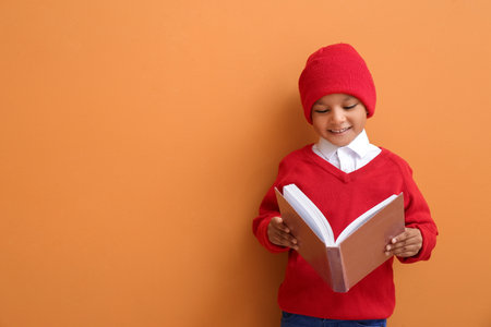 Cute African-American boy with book on color backgroundの写真素材