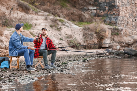 Young men fishing on the riverの写真素材