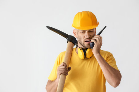 Miner man with two-way radio on light background