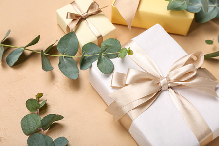 Eucalyptus leaves and gifts for Women's Day celebration on beige backgroundの写真素材