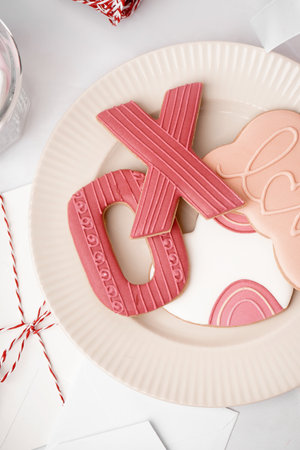 Plate with tasty cookies and envelopes on light table, closeup. Valentine's Day celebrationの写真素材