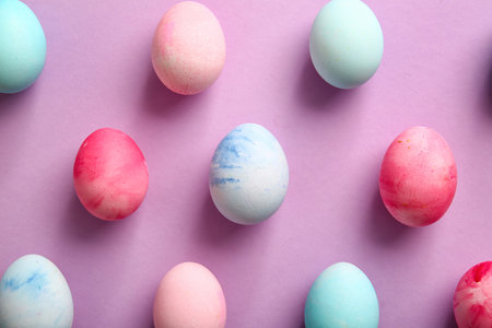 Composition with painted Easter eggs on lilac backgroundの写真素材