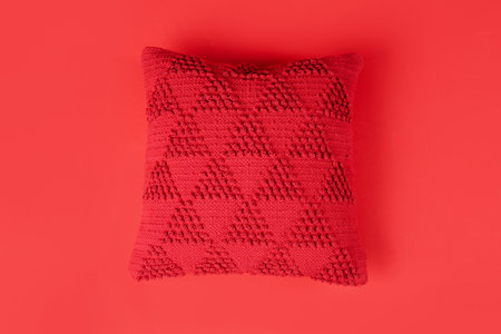 Stylish decorative pillow on red backgroundの写真素材