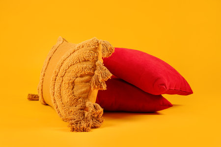 Decorative pillows on yellow background