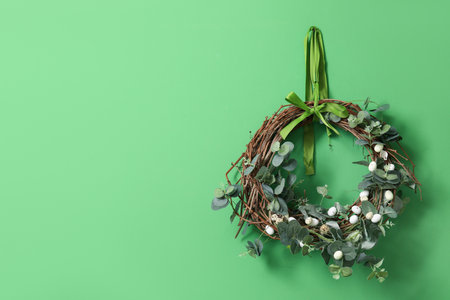 Easter wreath with eucalyptus and eggs on green wallの写真素材