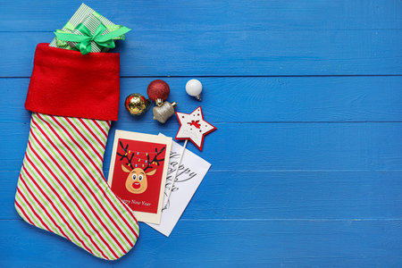 Composition with Christmas sock on color wooden background