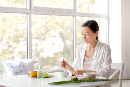 Beautiful young woman with cosmetic products in bathroomの写真素材