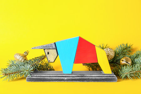 Figurine of bull and New Year decor on color background