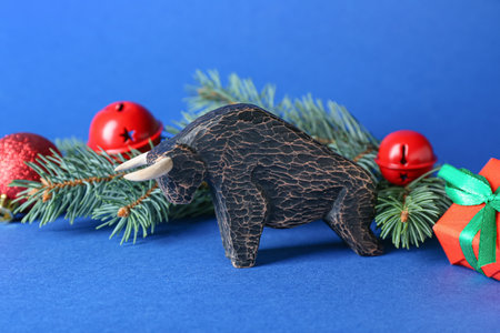 Figurine of bull and New Year decor on color backgroundの写真素材