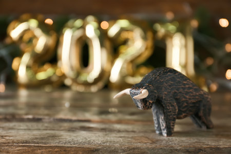 Figurine of bull as symbol of year 2021 on wooden table