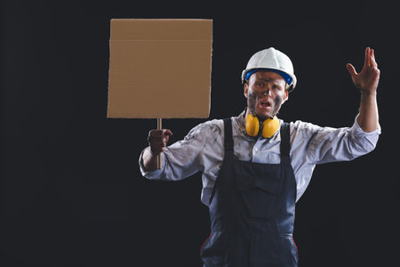 Protesting miner man with placard on dark background
