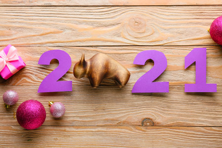 New Year composition with figurine of bull on wooden background