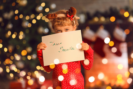 Cute little child with letter to Santa at homeの写真素材