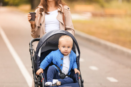 Woman and her cute baby in stroller outdoorsの写真素材