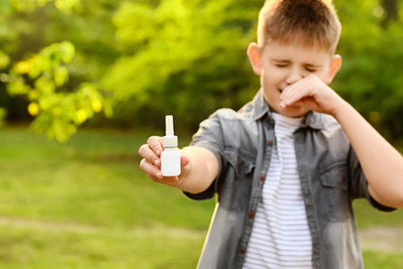 Little allergic boy with remedy outdoorsの写真素材
