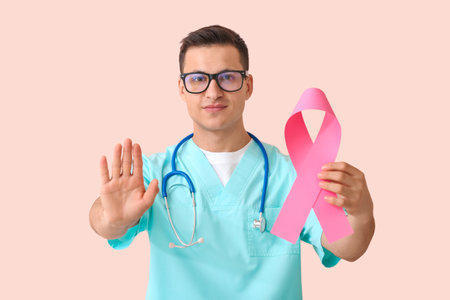 Doctor with pink ribbon on color background. breast cancer awareness conceptの写真素材