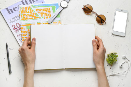 Woman with blank book at table, top viewの写真素材